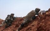 Des combattants syriens soutenus par la Turquie stationnés à un poste situé aux abords de la ville de Marea, une zone rurale du nord d'Alep, le long de la ligne de front avec les secteurs détenus par les Forces démocratiques syriennes, le 20 août 2022. (Crédit :  Aaref WATAD / AFP)