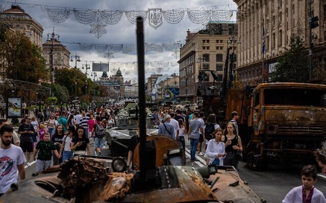 Des Ukrainiens regardent des équipements militaires russes détruits dans la rue Khreshchatyk, à Kiev, le 24 août 2022. (Crédit : Dimitar DILKOFF/AFP)