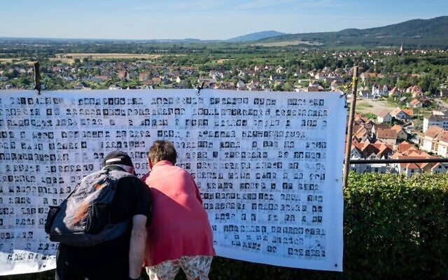 Des visiteurs regardent des photos de "Malgré-nous" sur un Mur des noms, lors d'une cérémonie marquant le 80e anniversaire d'un décret nazi ordonnant l'incorporation forcée des citoyens d'Alsace et de Moselle dans la Wehrmacht, l'armée régulière allemande, pendant la Seconde Guerre mondiale, à Obernai, dans l'est de la France, le 25 août 2022. - (Crédit : PATRICK HERTZOG / AFP) Des visiteurs regardent des photos de "Malgré-nous" sur un Mur des noms, lors d'une cérémonie marquant le 80e anniversaire d'un décret nazi ordonnant l'incorporation forcée des citoyens d'Alsace et de Moselle dans la Wehrmacht, l'armée régulière allemande, pendant la Seconde Guerre mondiale, à Obernai, dans l'est de la France, le 25 août 2022. - (Crédit : PATRICK HERTZOG / AFP)