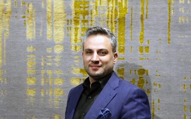 Le négociant Abbas Arsin pose à côté d'un tapis d'Ispahan avec des motifs jaunes et verts en velours à la 29e exposition du tapis artisanal organisé dans la capitale iranienne de Téhéran, le 26 août 2022. (Crédit : AFP) Le négociant Abbas Arsin pose à côté d'un tapis d'Ispahan avec des motifs jaunes et verts en velours à la 29e exposition du tapis artisanal organisé dans la capitale iranienne de Téhéran, le 26 août 2022. (Crédit : AFP)