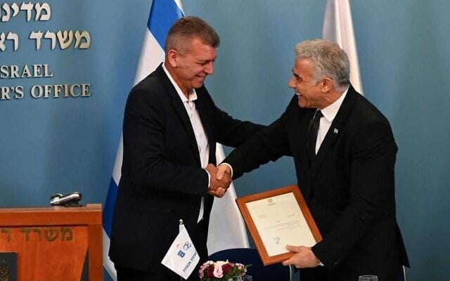 Le Premier ministre Yair Lapid (R) serre la main du nouveau directeur général de la Commission de l'énergie atomique d'Israël, Moshe Edri, le 1er août 2022. (Crédit : Haim Zach/GPO) Le Premier ministre Yair Lapid (R) serre la main du nouveau directeur général de la Commission de l'énergie atomique d'Israël, Moshe Edri, le 1er août 2022. (Crédit : Haim Zach/GPO)