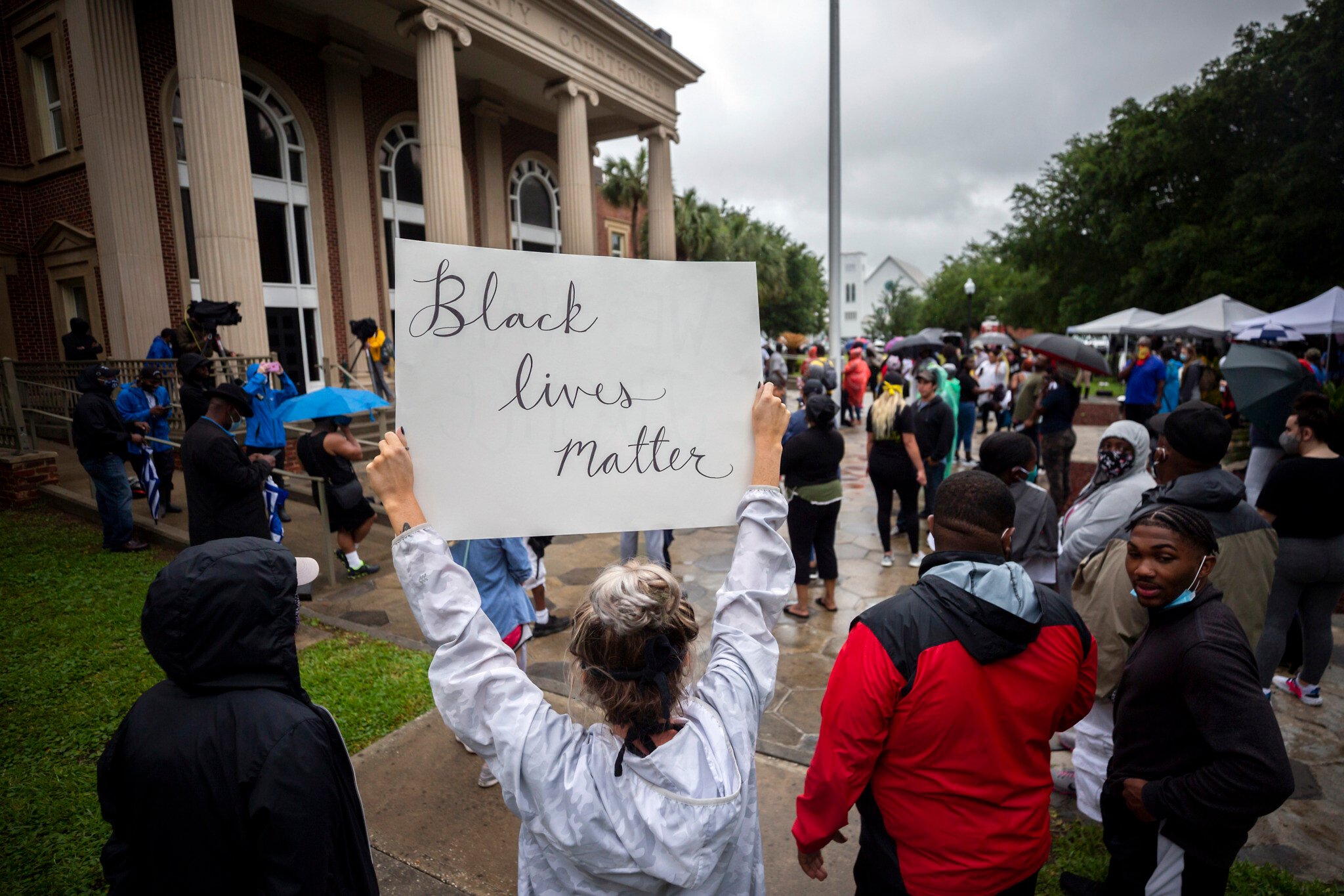 Des manifestants se rassemblent devant le palais de justice lors d'une audience préliminaire pour Travis McMichael, Gregory McMichael et William Bryan, les trois hommes sont accusés d'avoir tiré sur Ahmaud Arbery alors qu'il courait dans leur quartier, à Brunswick, en Géorgie, le 4 juin 2020. (Crédit : Stephen B. Morton/AP)