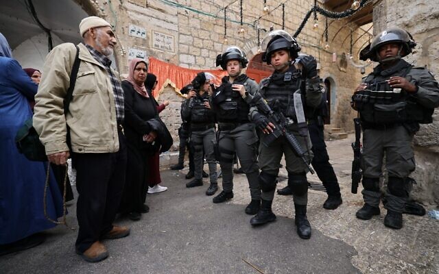 Des Palestiniens font face à des agents de la Police des frontières israélienne qui patrouillent devant la Porte des lions dans la Vieille Ville de Jérusalem, le 17 avril 2022. (Crédit: Ahmad Gharabli/AFP)