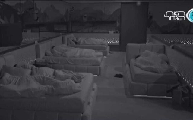 Les participants à l'émission israélienne "Big Brother" dormant juste avant qu'une sirène de raid aérien ne retentisse dans la maison, le 7 août 2022. (Crédit : Capture d'écran)