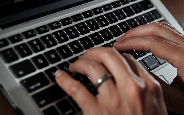 Photo du 19 juin 2017 représentant une personne en train de taper sur le clavier d’un ordinateur portable (Crédit : AP Photo/Elise Amendola, Fichier)