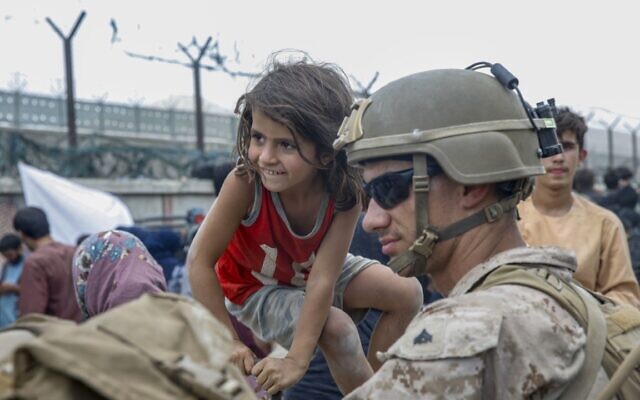 Un Marine de la Special Purpose Marine Air-Ground Task Force - Crisis Response - Central Command, patientant avec un enfant lors d'une évacuation à l'aéroport international Hamid Karzai de Kaboul, en Afghanistan, le 20 août 2021. (Crédit : Caporal suppléant Nicholas Guevara/US Marine Corps via AP) Un Marine de la Special Purpose Marine Air-Ground Task Force - Crisis Response - Central Command, patientant avec un enfant lors d'une évacuation à l'aéroport international Hamid Karzai de Kaboul, en Afghanistan, le 20 août 2021. (Crédit : Caporal suppléant Nicholas Guevara/US Marine Corps via AP)