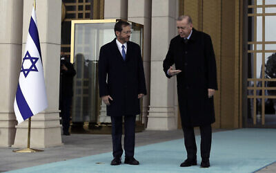 Le président turc Recep Tayyip Erdogan, à droite, montre le chemin au président Isaac Herzog lors d'une cérémonie de bienvenue, à Ankara, Turquie, le 9 mars 2022. (Crédit : Burhan Ozbilici/AP)