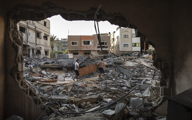 Des Palestiniens inspectent leur maison qui a été touchée par une frappe aérienne israélienne dans la ville de Gaza, lundi 8 août 2022. (Crédit : AP Photo/Fatima Shbair) Des Palestiniens inspectent leur maison qui a été touchée par une frappe aérienne israélienne dans la ville de Gaza, lundi 8 août 2022. (Crédit : AP Photo/Fatima Shbair)