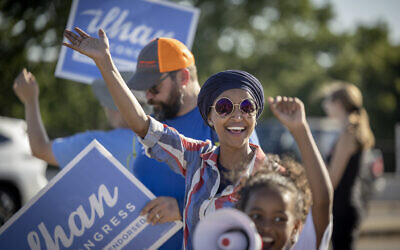 La représentante américaine Ilhan Omar salue les passants pour obtenir leur soutien lors d'un événement d'engagement des électeurs à l'angle des avenues Broadway et Central à Minneapolis, le mardi 9 août 2022. (Crédit : Elizabeth Flores/Star Tribune via AP)