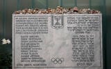 Une plaque commémorative à la mémoire des onze athlètes israéliens et d'un policier allemand tués lors d'une attaque terroriste pendant les Jeux olympiques de 1972, se trouve dans l'ancien logement de l'équipe israélienne dans le village olympique de Munich, en Allemagne. Photo prise le 27 août 2022. (Crédit : AP Photo/Matthias Schrader)