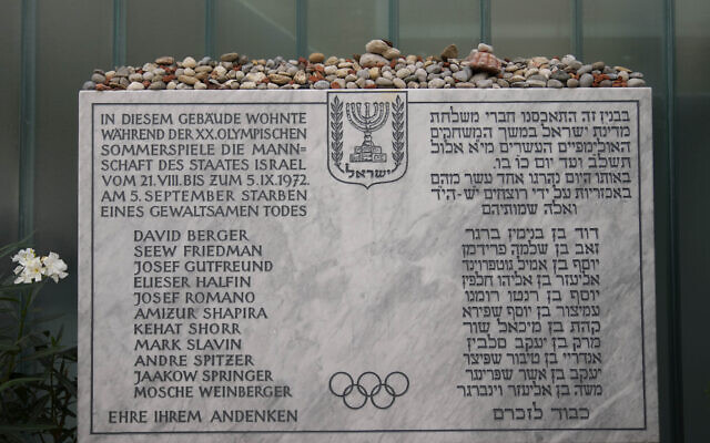 Une plaque commémorative à la mémoire des onze athlètes israéliens et d'un policier allemand tués lors d'une attaque terroriste pendant les Jeux olympiques de 1972, se trouve dans l'ancien logement de l'équipe israélienne dans le village olympique de Munich, en Allemagne. Photo prise le 27 août 2022. (Crédit : AP Photo/Matthias Schrader)