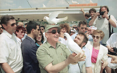 Une colombe de la paix se perche sur la tête de l’ex-président soviétique Mikhaïl Gorbatchev, le lundi 15 juin 1992, alors qu’il libère un autre oiseau lors d’un voyage d'agrément sur le lac de Tibériade, en Israël. (Crédit : AP Photo/Jerome Delay)