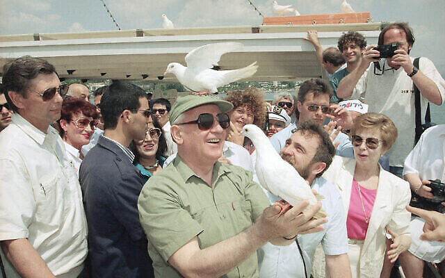 Une colombe de la paix se perche sur la tête de l’ex-président soviétique Mikhaïl Gorbatchev, le lundi 15 juin 1992, alors qu’il libère un autre oiseau lors d’un voyage d'agrément sur le lac de Tibériade, en Israël. (Crédit : AP Photo/Jerome Delay) Une colombe de la paix se perche sur la tête de l’ex-président soviétique Mikhaïl Gorbatchev, le lundi 15 juin 1992, alors qu’il libère un autre oiseau lors d’un voyage d'agrément sur le lac de Tibériade, en Israël. (Crédit : AP Photo/Jerome Delay)