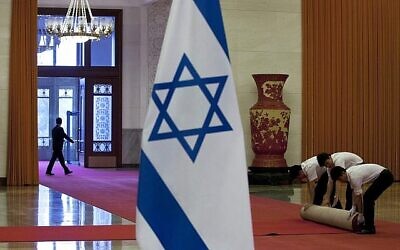 Les travailleurs roulent un tapis rouge après la cérémonie de bienvenue tenue par le Premier ministre chinois Li Keqiang pour le Premier ministre Benjamin Netanyahu dans la Grande Salle du Peuple à Pékin, en Chine, le mercredi 8 mai 2013. (Crédit : AP/Alexander F. Yuan)