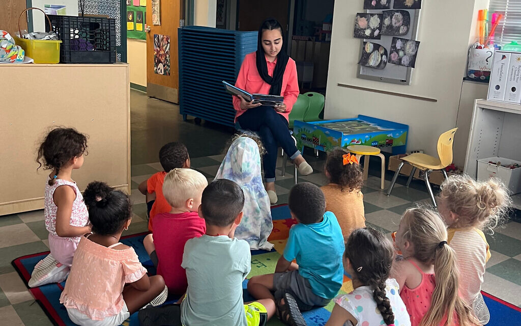 Une réfugiée afghane faisant la lecture à des enfants au Centre communautaire juif du Grand Harrisburg où elle travaille comme assistante dans le jardin d'enfants, en Pennsylvanie. (Crédit : JCC du Grand Harrisburg)