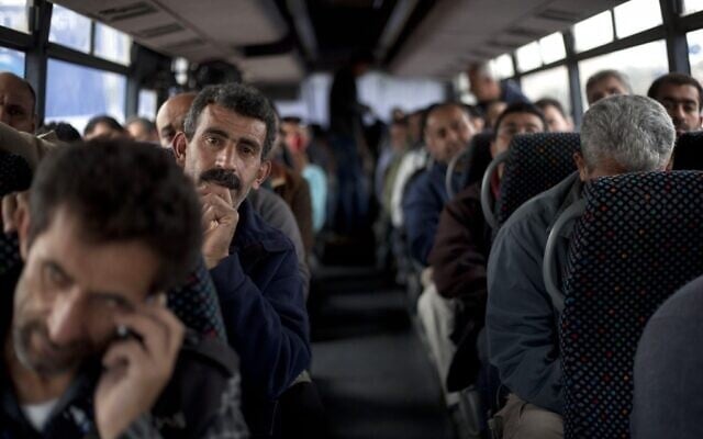Des ouvriers palestiniens à bord d'un bus en route vers la Cisjordanie après avoir travaillé dans la région de Tel Aviv, en Israël, lundi 4 mars 2013. (Crédit : AP/Ariel Schalit)