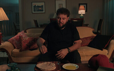 Mo Amer, dans le rôle de Mo Najjar, mange de l’huile d’olive et de la pita, dans un épisode de la série Netflix 'Mo.' (Crédit : Netflix)