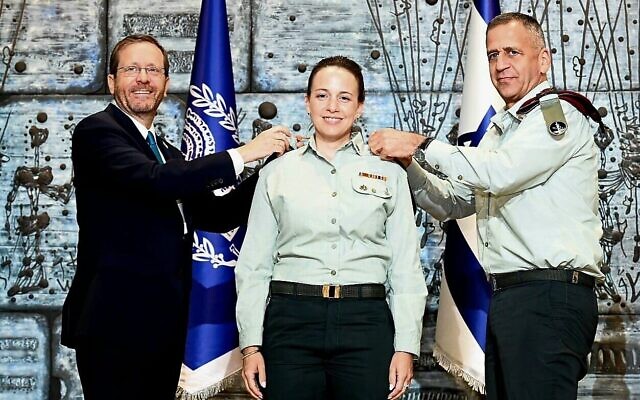 Le président Isaac Herzog, à gauche, et le chef d'État-major israélien Aviv Kohavi, à droite, remettent à Naama Rosen-Grimberg le grade de général de brigade à la résidence du président, le 31 juillet 2022. (Crédit : Haim Zach/GPO) Le président Isaac Herzog, à gauche, et le chef d'État-major israélien Aviv Kohavi, à droite, remettent à Naama Rosen-Grimberg le grade de général de brigade à la résidence du président, le 31 juillet 2022. (Crédit : Haim Zach/GPO)