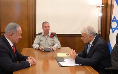 Le Premier ministre Yair Lapid informant le leader de l'opposition Benjamin Netanyahu au sujet de l'Iran et de l'accord nucléaire émergent, le 29 août 2022. (Crédit : Amos Ben Gershom/GPO)