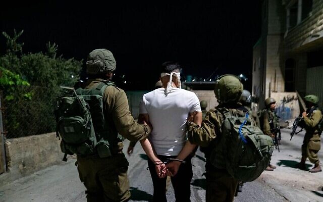 Les forces de sécurité israéliennes arrêtent un suspect terroriste en Cisjordanie, le 6 août 2022. L'armée a déclaré avoir arrêté 20 Palestiniens, dont 19 affiliés au Jihad islamique palestinien dans des villes et villages de Cisjordanie. (Crédit : armée)