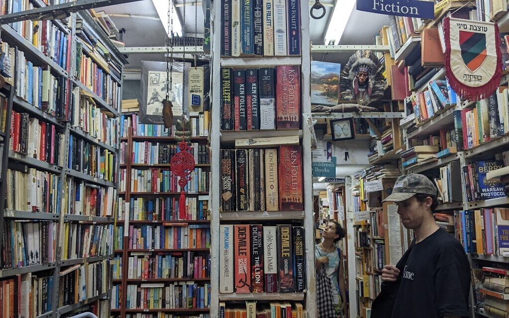  Des clients parcourant la librairie Halper à Tel Aviv, le 6 juillet 2022. (Crédit : Melanie Lidman/Times of Israel)