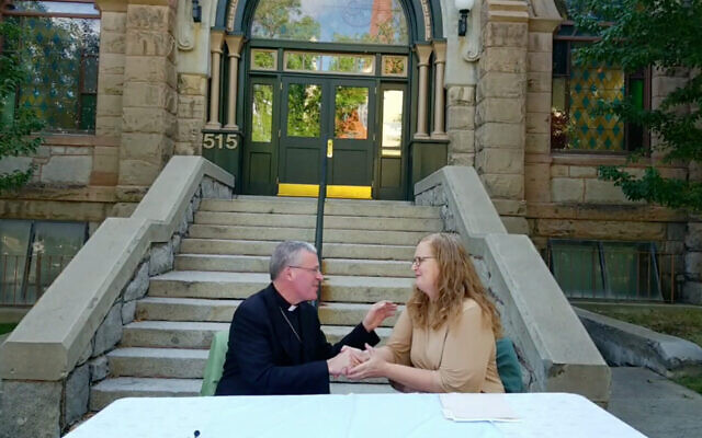Rebecca Stanfel, présidente du conseil d'administration du Montana Jewish Project, serrant la main de l'évêque Austin Vetter du diocèse d'Helena lors de la cérémonie de restitution du bâtiment à la communauté juive. (Crédit : Capture d'écran/Facebook Live, via JTA) Rebecca Stanfel, présidente du conseil d'administration du Montana Jewish Project, serrant la main de l'évêque Austin Vetter du diocèse d'Helena lors de la cérémonie de restitution du bâtiment à la communauté juive. (Crédit : Capture d'écran/Facebook Live, via JTA)