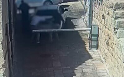 Capture d’écran d'une caméra de sécurité montrant un homme attaquant deux personnes lors d'une dispute de stationnement, le 18 août 2022. (Crédit : Police israélienne)