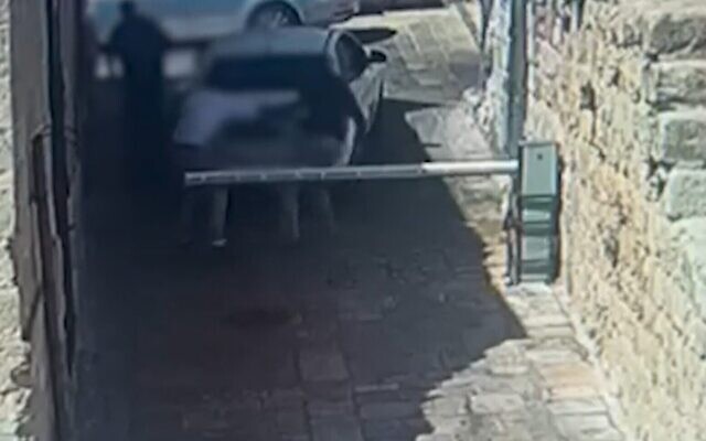 Capture d’écran d'une caméra de sécurité montrant un homme attaquant deux personnes lors d'une dispute de stationnement, le 18 août 2022. (Crédit : Police israélienne)