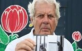 L'ancien joueur de handball Klaus Langhoff, qui a été témoin du saccage des Jeux olympiques de Munich en 1972, montre l'une de ses photos lors d'un entretien avec l'AFP à Rostock, dans le nord-est de l'Allemagne, le 25 août 2022. (Crédit : Tobias Schwarz / AFP)