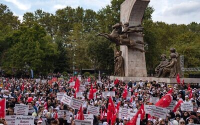 Des manifestants brandissent des pancartes et des drapeaux lors d'un rassemblement anti-LGBT organisé par des organisations pro-islamiques à Istanbul le 18 septembre 2022. (Crédit :  Yasin AKGUL / AFP)