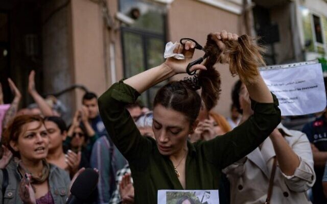 Nasibe Samsaei, une Iranienne vivant en Turquie, coupe sa queue de cheval lors d'une manifestation devant le consulat d'Iran à Istanbul le 21 septembre 2022, suite à la mort d'une Iranienne après son arrestation par la police des mœurs du pays à Téhéran.(Crédit : Yasin AKGUL / AFP) Nasibe Samsaei, une Iranienne vivant en Turquie, coupe sa queue de cheval lors d'une manifestation devant le consulat d'Iran à Istanbul le 21 septembre 2022, suite à la mort d'une Iranienne après son arrestation par la police des mœurs du pays à Téhéran.(Crédit : Yasin AKGUL / AFP)
