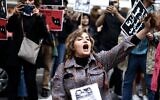 Illustration : Une femme se coupant les cheveux lors d'une manifestation de soutien à Mahsa Amini devant l'ambassade d'Iran, à Bruxelles, le 23 septembre 2022. (Crédit : Kenzo Tribouillard/AFP)