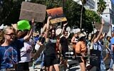 Des jeunes et des militants de Los Angeles tenant des pancartes alors qu'ils participent à une grève mondiale pour le climat visant à déclarer une urgence de justice climatique devant l'hôtel de ville de Los Angeles, le 23 septembre 2022.
(Crédit : Frederic J. Brown/AFP)