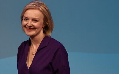 La nouvelle chef du Parti conservateur et Premier ministre élu de Grande-Bretagne, Liz Truss, sourit alors qu'elle arrive sur scène pour prononcer un discours lors d'un événement visant à annoncer le gagnant de la course à la direction du Parti conservateur, dans le centre de Londres, le 5 septembre 2022 (Crédit : Adrian DENNIS/AFP)