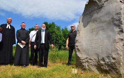 Le grand rabbin polonais Michael Schudrich, deuxième à partir de la droite en cravate bleue, prend la parole à côté d'ecclésiastiques catholiques lors de la cérémonie de commémoration de Jedwabne, le 11 juillet 2021. (Crédit : Krzysztof Bielawski)