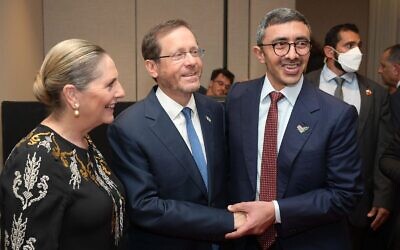 Le président Isaac Herzog et le ministre des Affaires étrangères des Émirats Sheikh Abdallah bin Zayed Al Nahyan se serrent la main lors d'une réception organisée par les Émirats pour marquer le deuxième anniversaire des accords d'Abraham, le 15 septembre 2022. (Crédit : Amos Ben-Gershom/GPO)