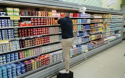 Un employé empile des produits dans un supermarché de la ville de Katzrin, sur le plateau du Golan, le 12 septembre 2022. Illustration (Crédit : Michael Giladi/Flash90)