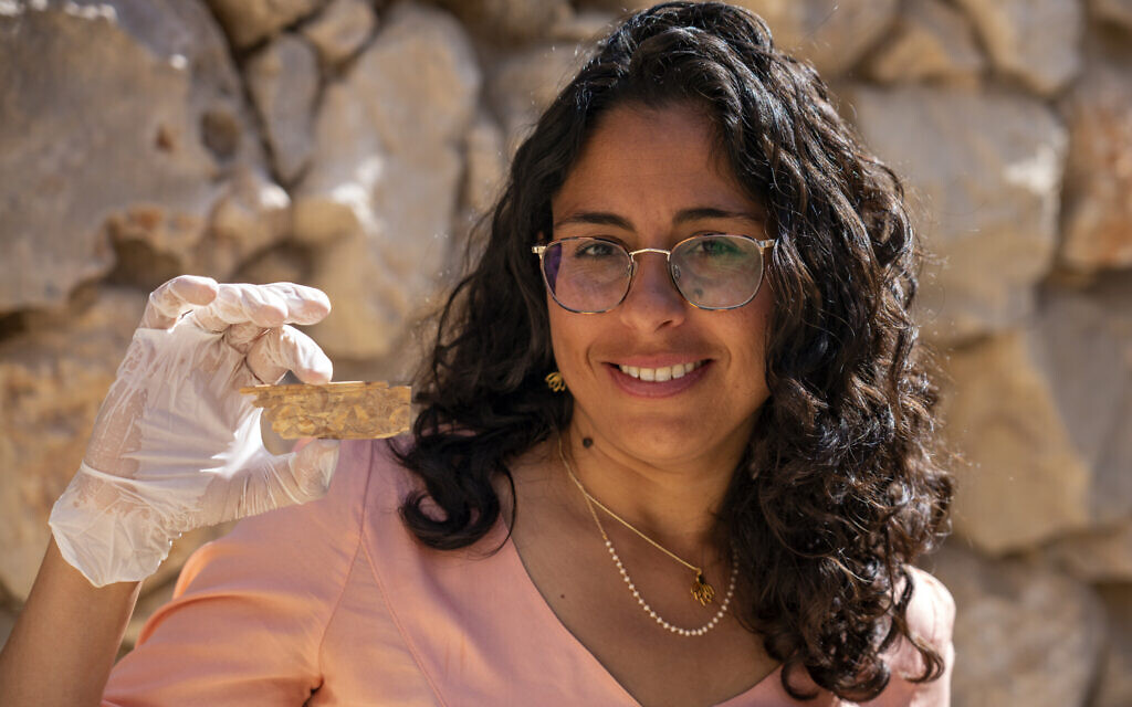 Reli Avisar de l'université de Tel Aviv avec une plaque d'ivoire du 8e et du 7e siècle avant l'ère commune décorée d'une fleur de lotus trouvée dans la Cité de David. (Crédit : Yaniv Berman, Israel Antiquities Authority)