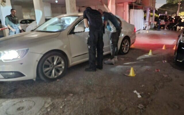 Des agents sur les lieux d'un double meurtre à Lod, où une mère d'une trentaine d'années et sa fille de 14 ans, l'une des deux jumelles, ont été tuées. La jumelle survivante a été gravement blessée, le 5 septembre 2022. (Crédit :  Police israélienne)