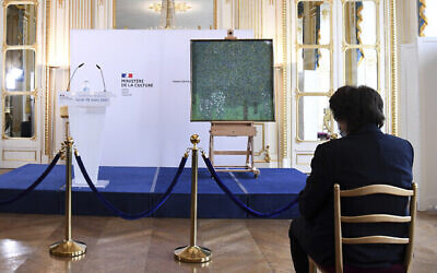 La ministre française de la Culture, Roselyne Bachelot, examine le tableau de 1905 « Rosiers sous les arbres » de Gustav Klimt lors d’une cérémonie au Musée d’Orsay à Paris, le 15 mars 2021, où le gouvernement français a restitué le tableau aux petits-enfants de la victime de la Shoah, Nora Stiasny, à qui il a été volé par les nazis pendant la Seconde Guerre mondiale. (Crédit : Alain Jocard/Pool Photo via AP)