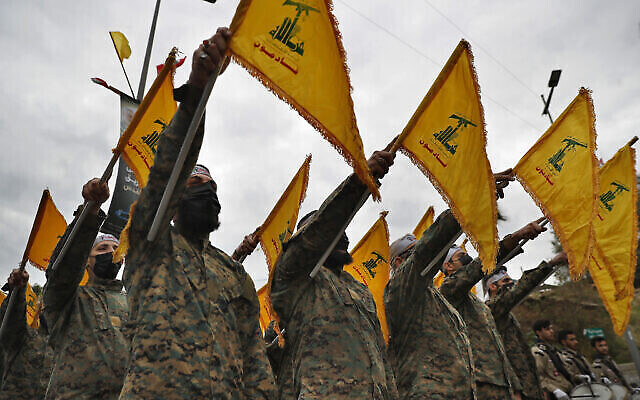 Des combattants du Hezbollah brandissant le drapeau de leur groupe devant une statue du général iranien Qassem Soleimani et lui prêtant serment d’allégeance, lors d’une cérémonie marquant le deuxième anniversaire de son assassinat, dans la banlieue sud de Beyrouth, au Liban, le 4 janvier 2022. (Crédit : AP Photo/Hussein Malla) Des combattants du Hezbollah brandissant le drapeau de leur groupe devant une statue du général iranien Qassem Soleimani et lui prêtant serment d’allégeance, lors d’une cérémonie marquant le deuxième anniversaire de son assassinat, dans la banlieue sud de Beyrouth, au Liban, le 4 janvier 2022. (Crédit : AP Photo/Hussein Malla)