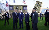 Le président américain Joe Biden serre la main du ministre israélien de la Défense Benny Gantz, alors qu’il visite des systèmes de défense aérienne, le 13 juillet 2022, à Tel Aviv, sous le regard du Premier ministre de l'époque, Yair Lapid, à la droite de Biden. (Crédit : AP/Evan Vucci)