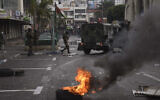 Les forces de sécurité palestiniennes affrontent des palestiniens suite à un raid d'arrestation contre des militants de la ville à Naplouse, en Cisjordanie, le 20 septembre 2022. (Crédit : AP Photo/Nasser Nasser)