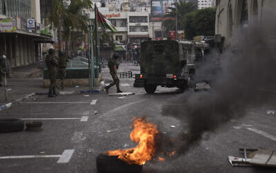 Les forces de sécurité palestiniennes affrontent des palestiniens suite à un raid d'arrestation contre des militants de la ville à Naplouse, en Cisjordanie, le 20 septembre 2022. (Crédit : AP Photo/Nasser Nasser)