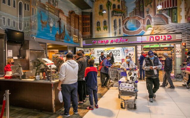 Illustration : Des personnes font leurs courses devant la succursale du supermarché Hatzi Hinam à Rishon Lezion, le 29 décembre 2021. (Crédit : Yossi Aloni/Flash90)