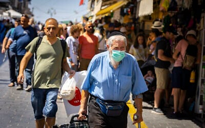 Des personnes, dont certaines portent des masques, faisant leurs courses au marché de Mahane Yehuda, à Jérusalem, le 7 juillet 2022. (Crédit : Olivier Fitoussi/Flash90)