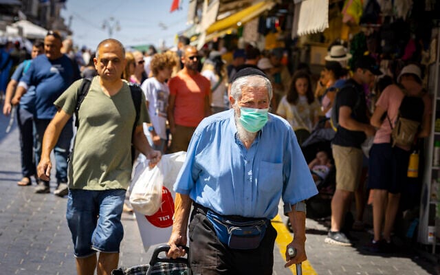 Des personnes, dont certaines portent des masques, faisant leurs courses au marché de Mahane Yehuda, à Jérusalem, le 7 juillet 2022. (Crédit : Olivier Fitoussi/Flash90) Des personnes, dont certaines portent des masques, faisant leurs courses au marché de Mahane Yehuda, à Jérusalem, le 7 juillet 2022. (Crédit : Olivier Fitoussi/Flash90)