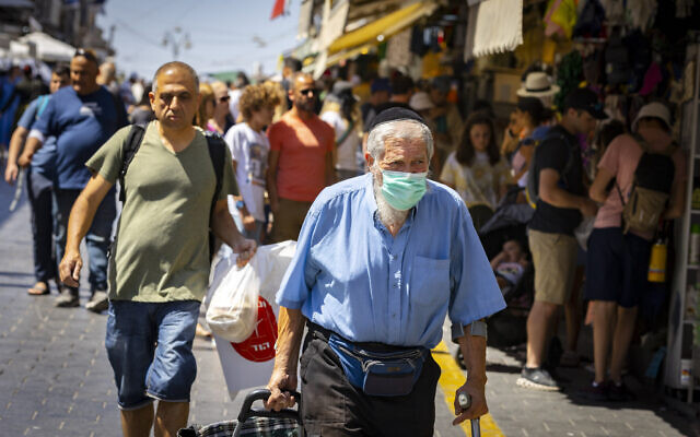 Des Israéliens, certains portant le masque, font leurs courses au marché mahane Yehuda de Jérusalem, le 7 juillet 2022. (Crédit : Olivier Fitoussi/Flash90) Des Israéliens, certains portant le masque, font leurs courses au marché mahane Yehuda de Jérusalem, le 7 juillet 2022. (Crédit : Olivier Fitoussi/Flash90)