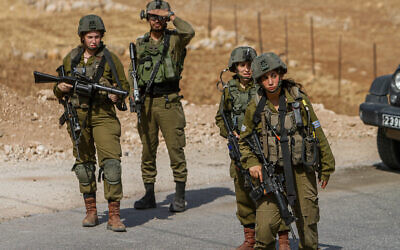 Des soldats israéliens bloquent la zone près du lieu d'une attaque par balle contre un bus sur la route 90 dans la vallée du Jourdain, le 4 septembre 2022. (Crédit : Nasser Ishtayeh/Flash90)