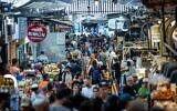 Les gens font se pressent au marché Mahane Yehuda de Jérusalem, le 25 septembre 2022, à la veille de Rosh Hashanah. (Crédit : Yonatan Sindel/Flash90)